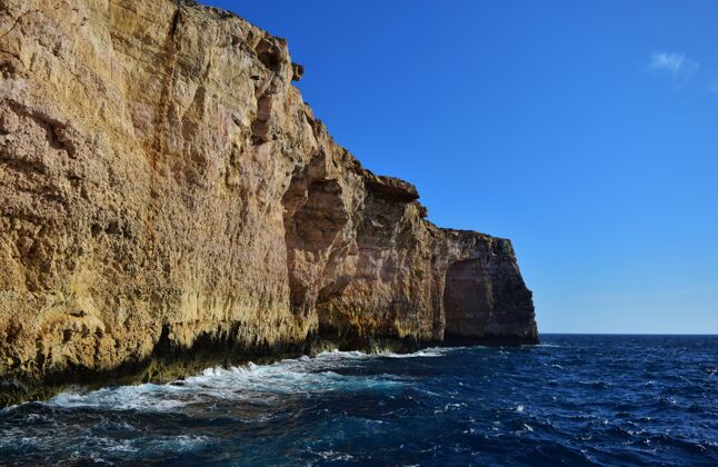 海浪美丽的拍摄珊瑚石灰岩海悬崖在米格拉伊尔费尔哈 马耳他群岛 马耳他海滩蓝色自然