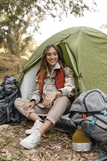 户外快乐的野营女孩在森林里坐在帐篷里露营旅游度假