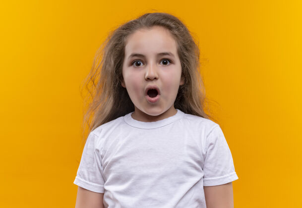白色惊讶的小女生穿着白色t恤在孤立的橙色背景下张嘴嘴巴女孩学校
