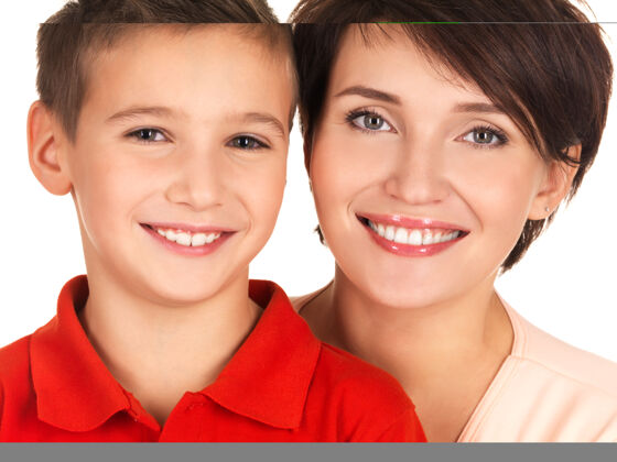 漂亮一位快乐的年轻母亲和8岁的儿子的画像学校男孩白色关系