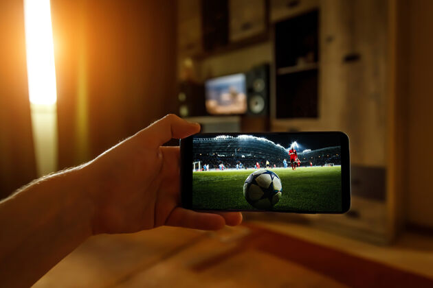 足球通过智能手机在家观看足球比赛从体育场广播足球网络突出显示足球