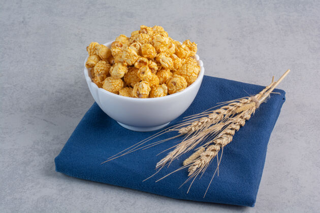 谷物一小碗涂着糖果的爆米花和麦秆放在大理石上糖果面粉爆米花