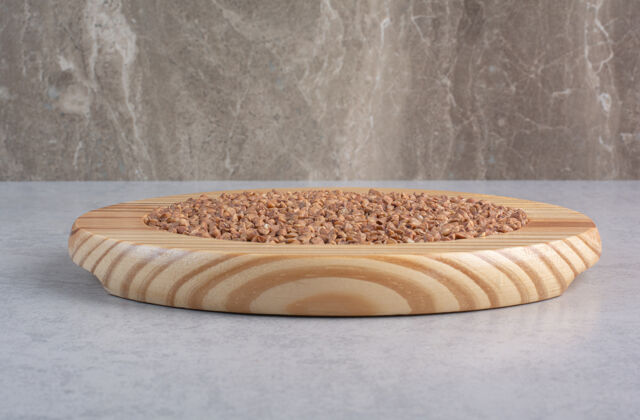盘子大理石上放着一堆长米粒的木板碳水化合物木制盘子谷物