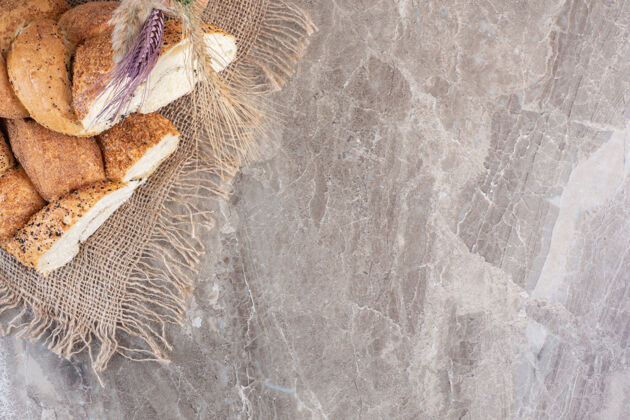 膳食涂有芝麻的切片面包 麦秆放在大理石上烘焙面包顶部视图