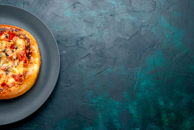 里面小奶酪比萨饼圆内形成深蓝色表面板顶视图生的质地成型