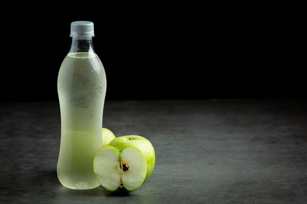 鸡尾酒一瓶绿色苹果健康果汁放在新鲜的绿色苹果旁边冰沙颜色苹果