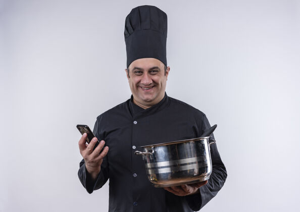 厨师微笑的中年男厨师身着厨师制服 手里拿着锅和电话中年男电话