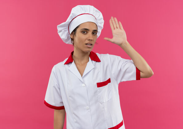 制服穿着厨师制服的年轻女厨师在隔离的粉色墙壁上展示停止手势 并留有复制空间女表情手势