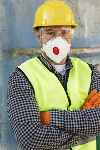 防护戴着防护眼镜和反光背心的男性工人的正面图垂直帽子预防