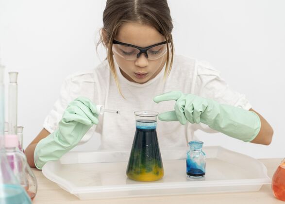 试管戴着安全眼镜的女孩在试管里做化学实验科学实验学校