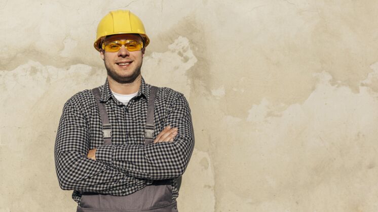 防护眼镜穿着制服 戴着防护手套和复印空间的男工人的正面图水平劳工安全帽