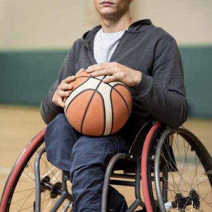 轮椅特写年轻的残疾人拿着球生活方式身体健康