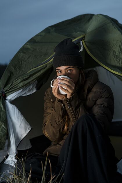 旅游晚上带着一杯茶露营的女人露营体验露营