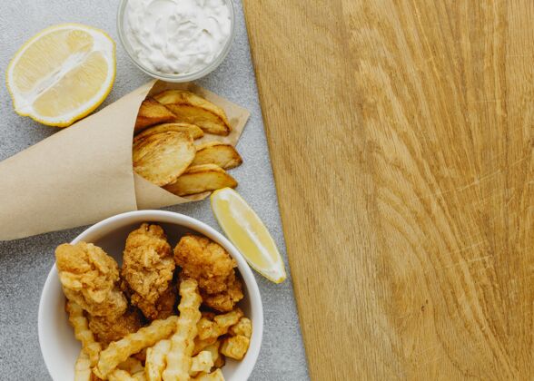英语鱼和薯条在碗和纸包装与复制空间和柠檬俯视图英国鱼土豆