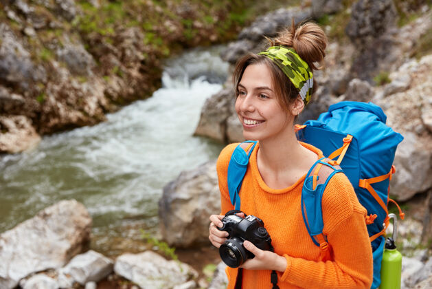 人类喜欢冒险的女性喜欢旅游探险 有徒步旅行和自然旅游 拍摄风景照片 手持专业相机头带溪流梦幻